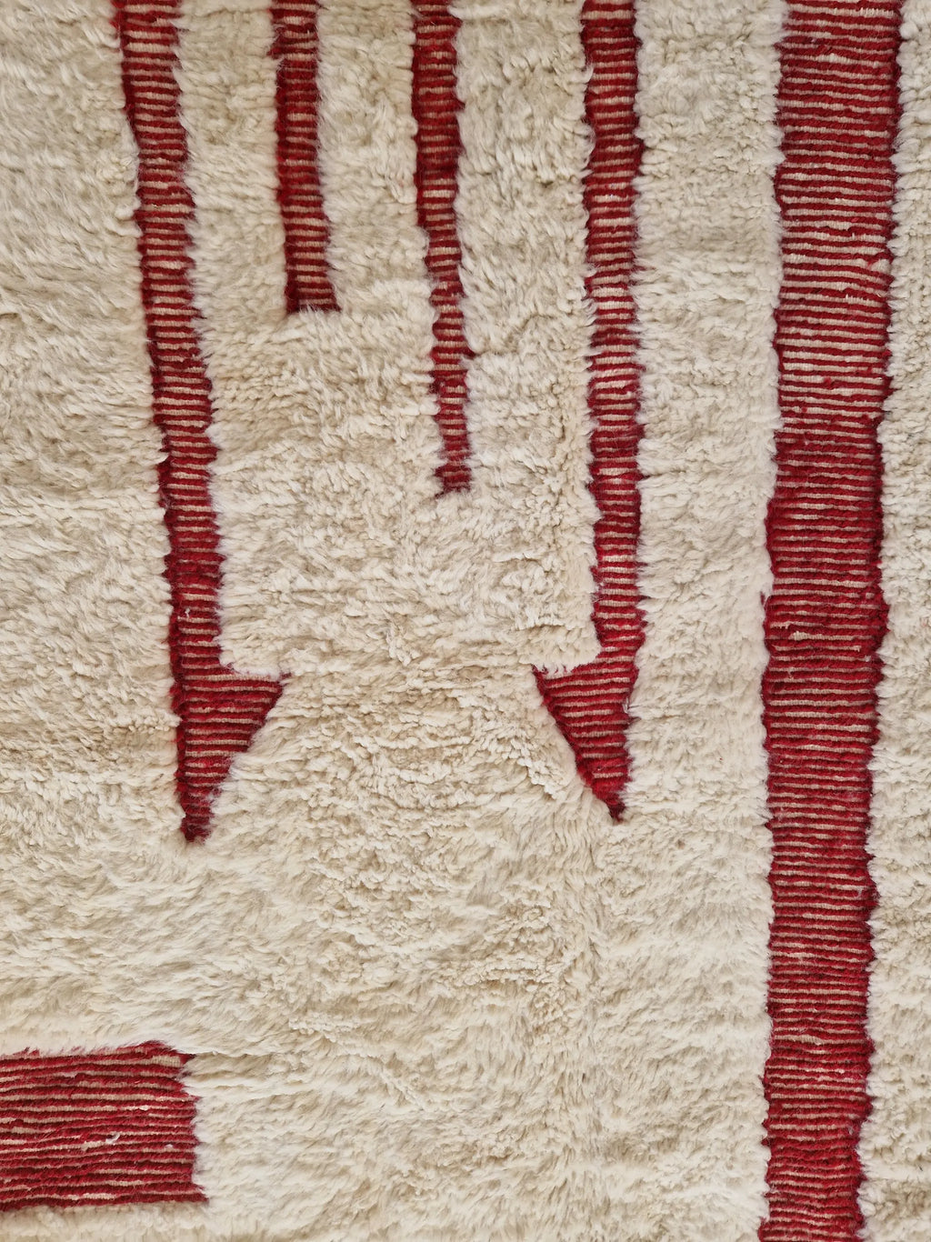 Tapis berbère beni ouarain noué à la main par des artisans marocains, aux motifs géométriques rouge en relief,