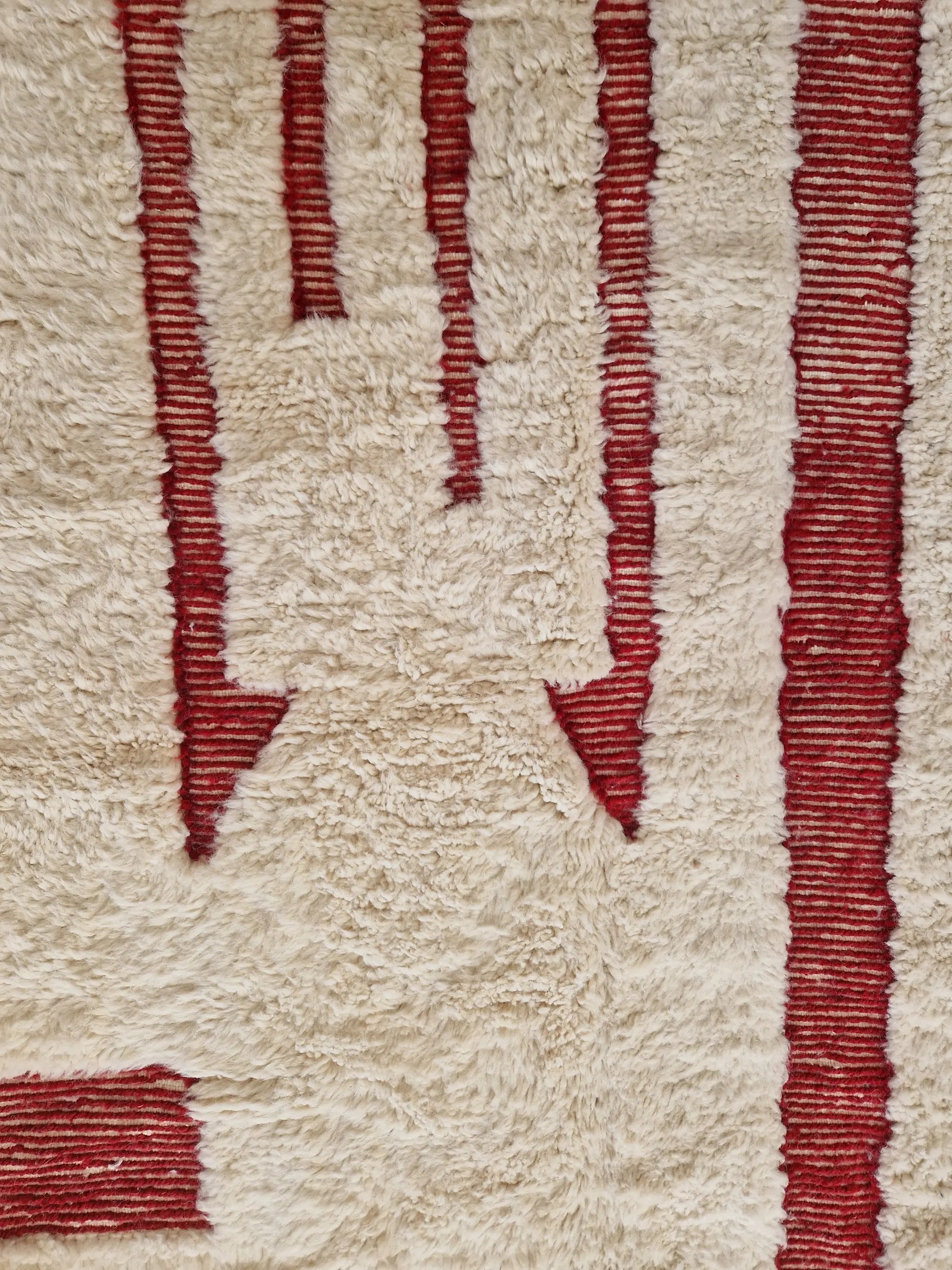 Tapis berbère beni ouarain noué à la main par des artisans marocains, aux motifs géométriques rouge en relief,