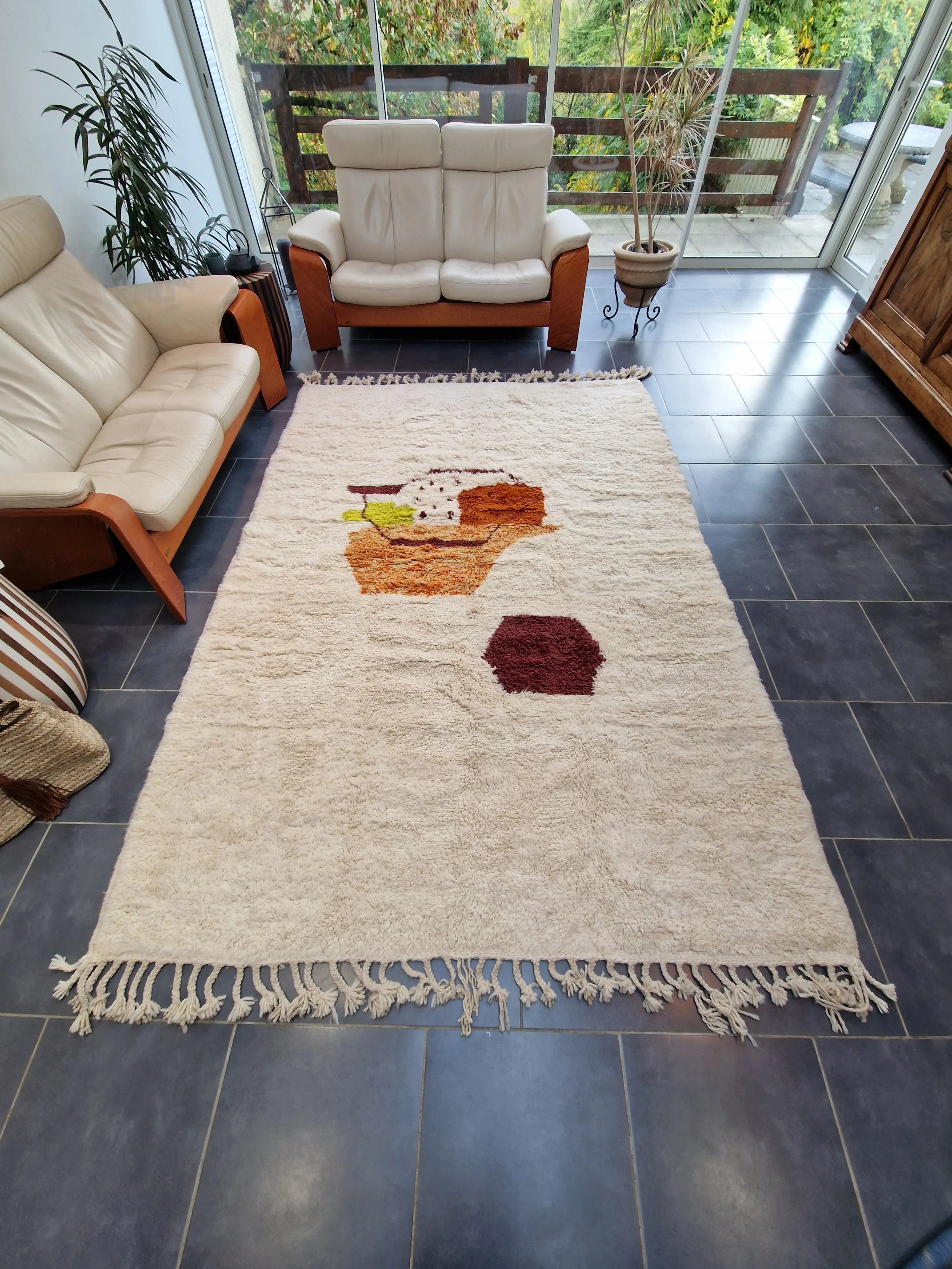 Sublimez votre intérieur avec ce tapis berbère authentique, noué à la main en laine naturelle. Ses motifs colorés sur fond ivoire, son épaisseur généreuse et son charme artisanal en font une pièce unique idéale pour un salon, une chambre ou un bureau chaleureux.