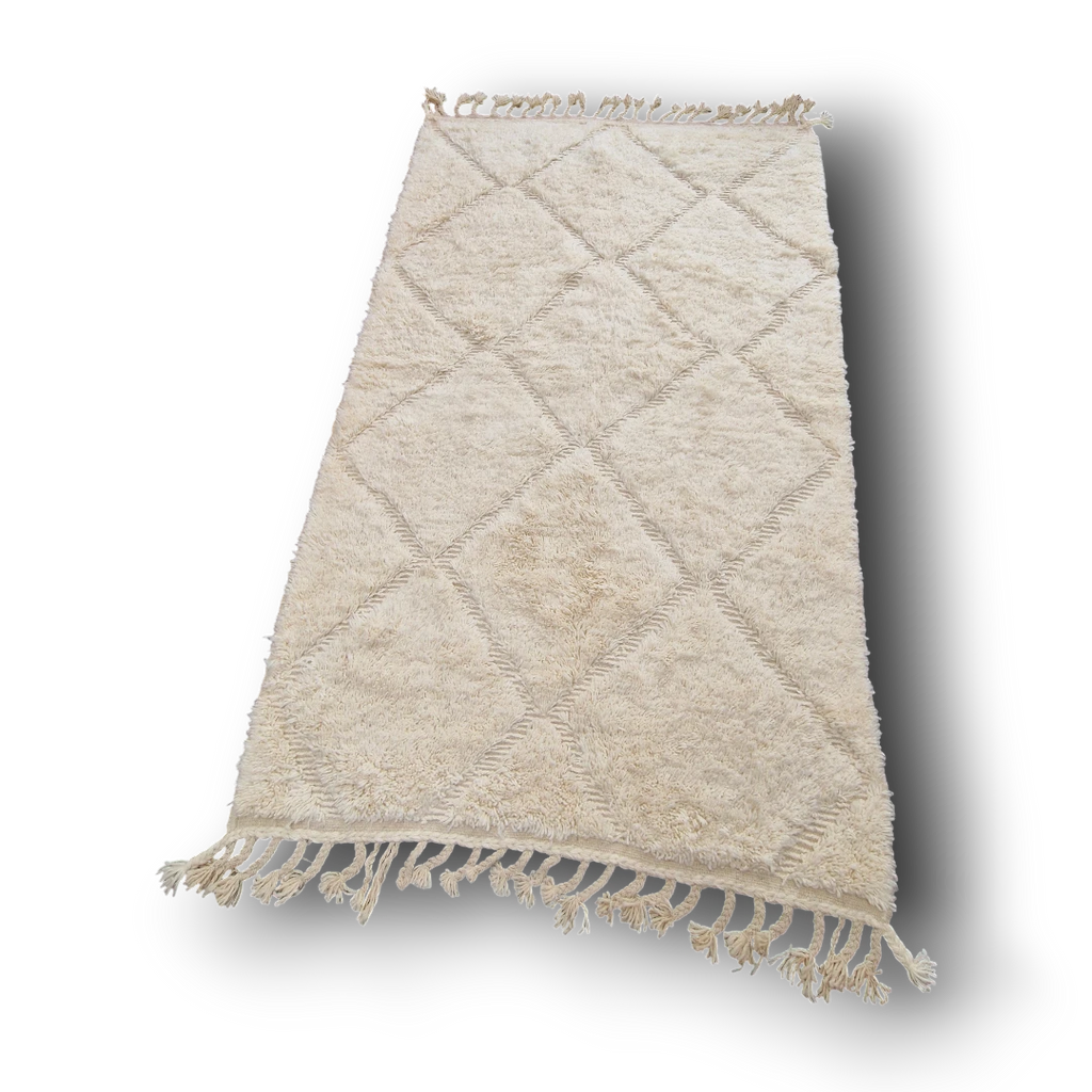 Tapis berbère Beni Ouarain en laine naturelle, tissé à la main au Maroc. Motifs en relief, douceur épaisse et charme artisanal. Pièce unique et chaleureuse.
