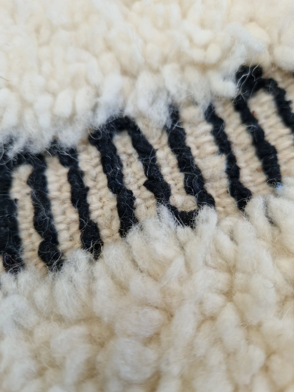 authentique tapis traditionnel marocain, tissé dans l'atlas par des Berbères, fait-mains en pure laine avec des motifs en relief modernes