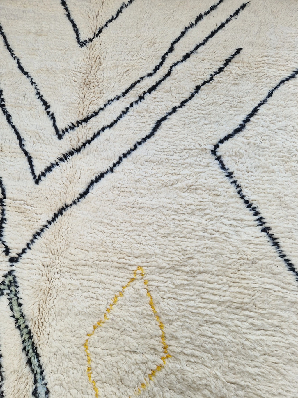 Tapis berbère beni ouarain en laine naturelle, tissé à la main au Maroc. Motifs colorés, douceur épaisse et charme artisanal. Pièce unique et chaleureuse.