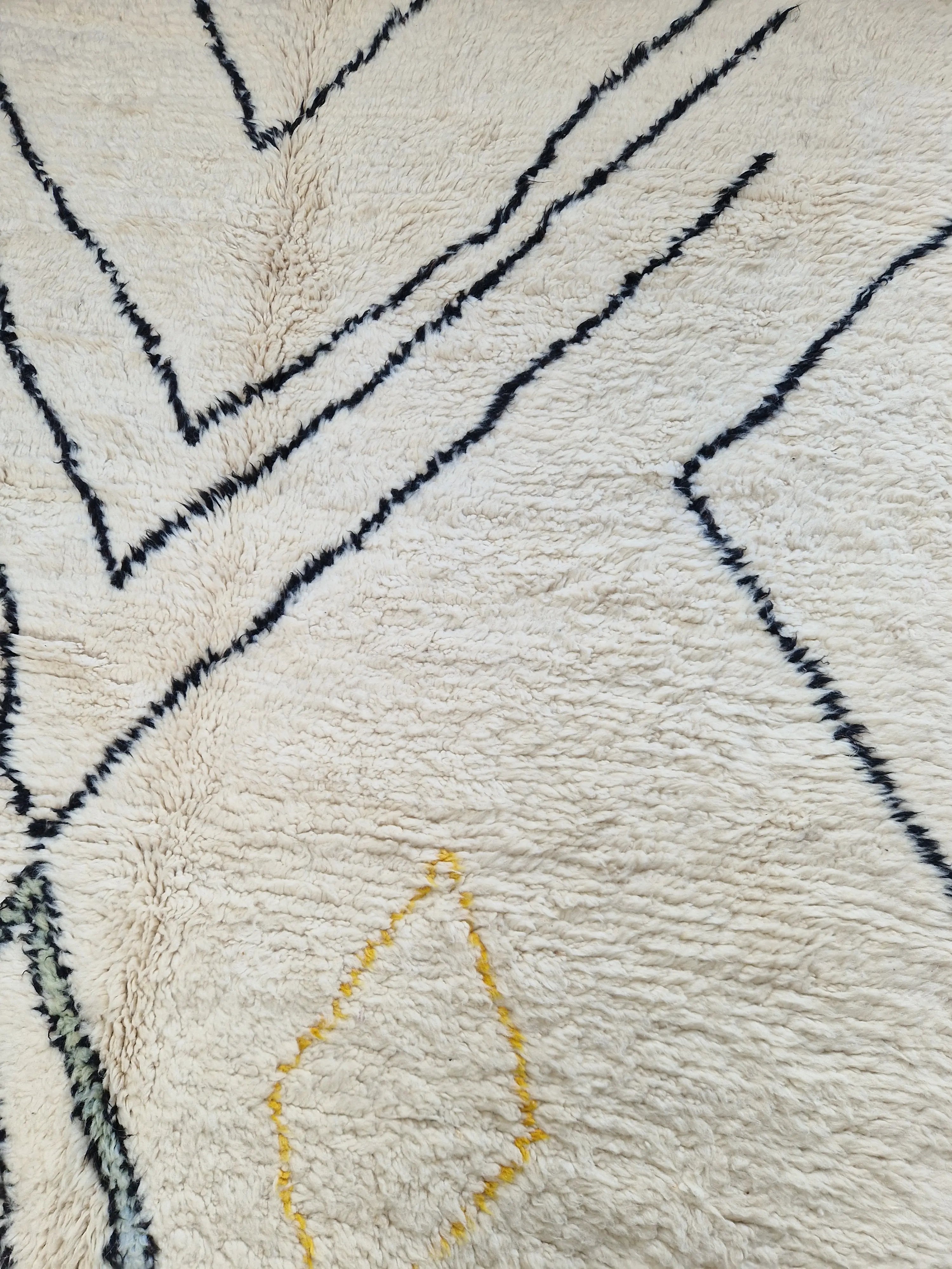 Tapis berbère beni ouarain en laine naturelle, tissé à la main au Maroc. Motifs colorés, douceur épaisse et charme artisanal. Pièce unique et chaleureuse.