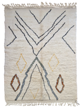 Tapis berbère beni ouarain en laine naturelle, tissé à la main au Maroc. Motifs colorés, douceur épaisse et charme artisanal. Pièce unique et chaleureuse.