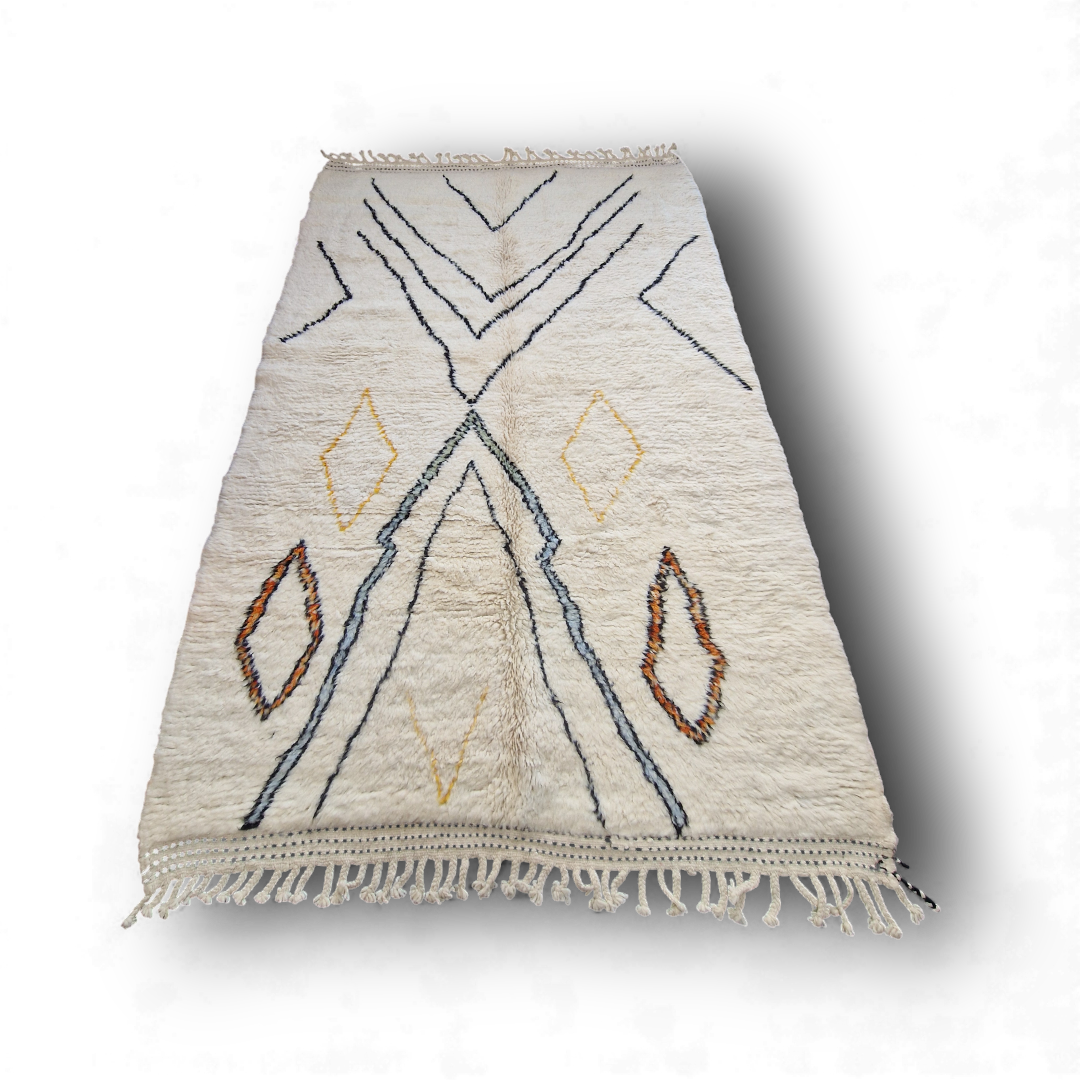 Tapis berbère beni ouarain en laine naturelle, tissé à la main au Maroc. Motifs colorés, douceur épaisse et charme artisanal. Pièce unique et chaleureuse.
