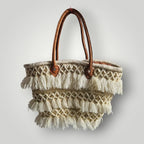 Panier tressé en feuilles de palmier, avec des poignée en cuir, et des franges en fil. Peut être utilisé en sac à main, en panier pour les courses, pour aller à la plage...