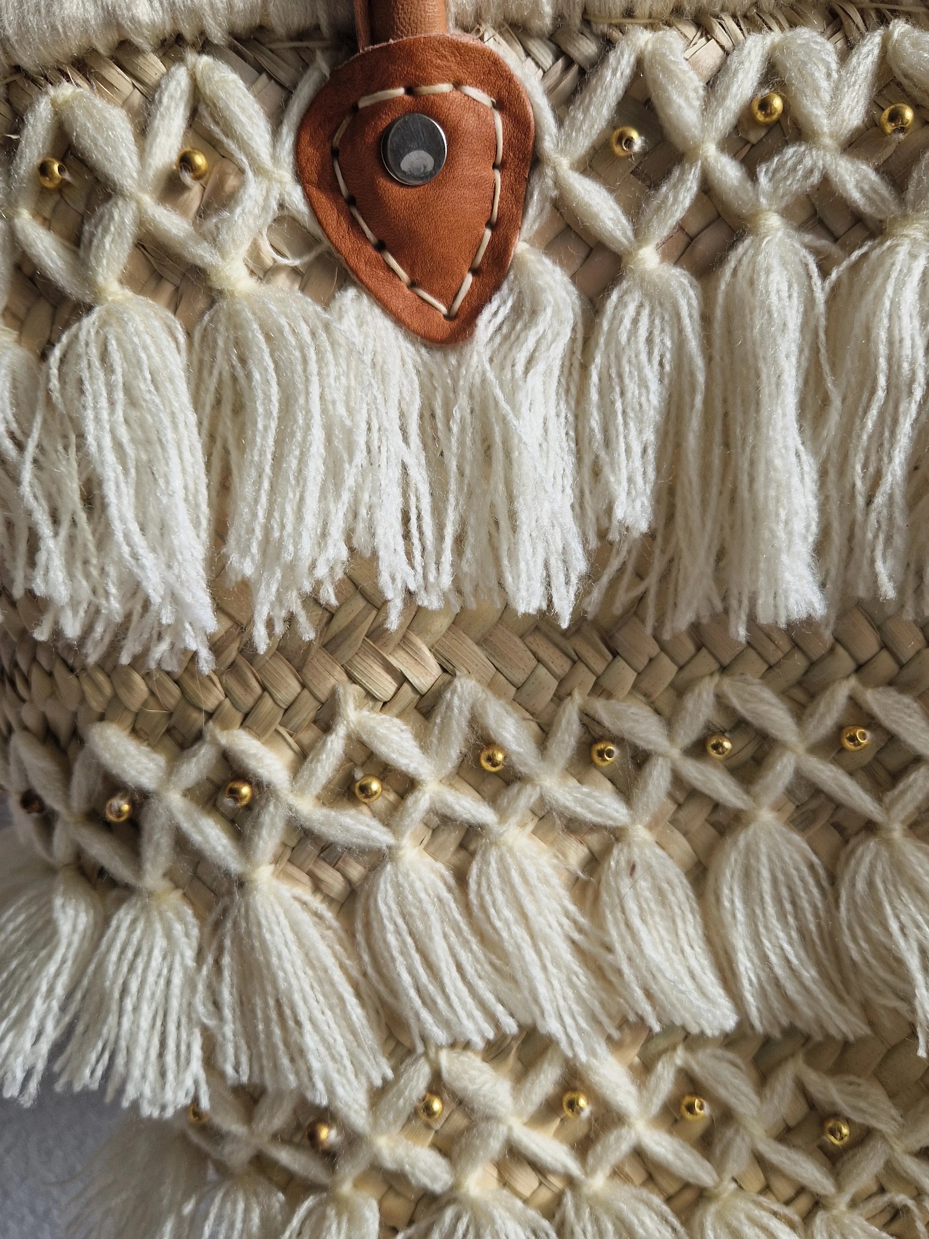 Panier tressé en feuilles de palmier, avec des poignée en cuir, et des franges en fil. Peut être utilisé en sac à main, en panier pour les courses, pour aller à la plage...